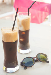 Two iced coffee on a reception table with vintage sunglasses
