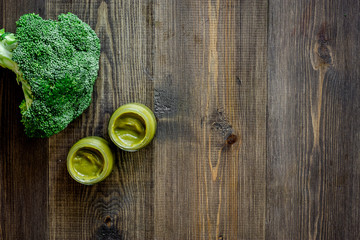 Broccoli puree for baby on dark wooden table background top view copyspace