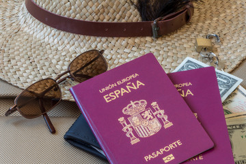 Tourism travel concept. Spanish passports, female hat, sunglasses, and money 