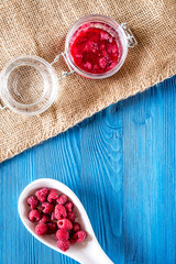 Homemade natural jam. Berries and sugar on blue wooden and canvas background top view copyspace