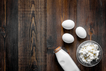Non GMO, prservatives-free organic food. Milk, cottage, eggs on dark wooden background top view copyspace