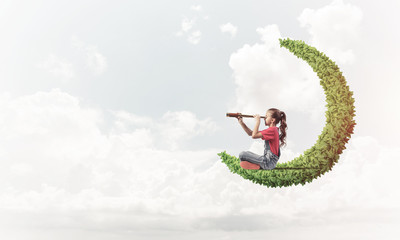 Concept of careless happy childhood with girl on green moon