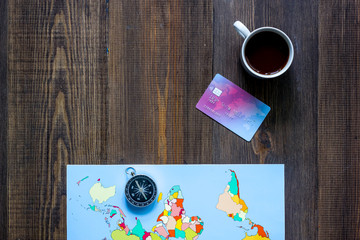 Planning trip. World map and compass wooden table background top view copyspace