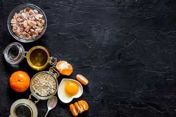 Porrige for breakfast with oranges and honey on black stone background top view copyspace