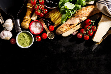 Fototapeta na wymiar Tasty fresh appetizing italian food ingredients on dark background. Ready to cook. Home Italian Healthy Food Cooking Concept. Toning.