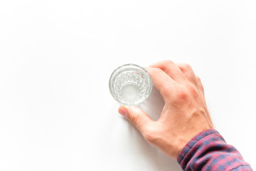 Man holding a glass of vodka on a white background