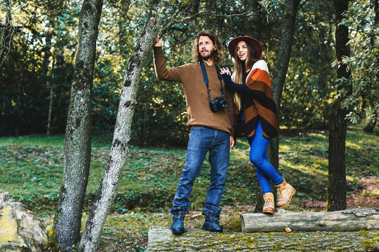 Hipster couple standing in the woods.