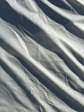 Grey protective fabric covering car, close up