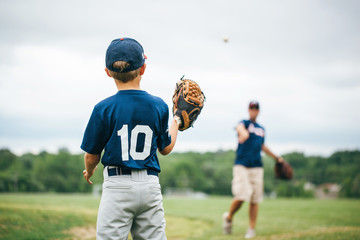 Baseball player playing with his father on field