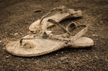 Dirty sandals in mud and sand