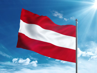 Fototapeta na wymiar Austria flag waving in the blue sky