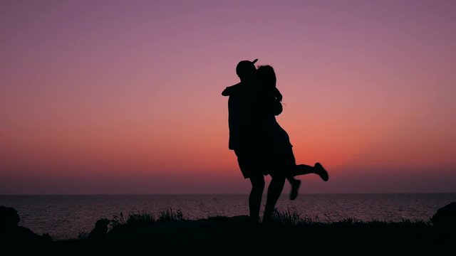 Young hipsters couple doing dancing and spinning around on amazing sunset. HD Slowmotion.