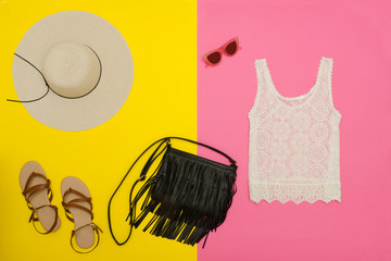 Female wardrobe. White top, handbag, sandals and hat. Bright pink-yellow background. fashion concept