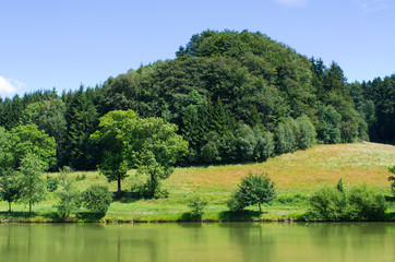 Pond surrounded by green meadows