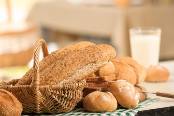 Basket with delicious bread on blurred background