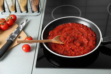 Frying pan with tomato sauce on electric stove