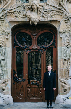 Attractive man wearing tuxedo in front of art deco entrance.