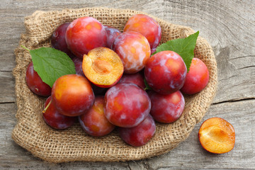 raw plum on old wooden table. top view