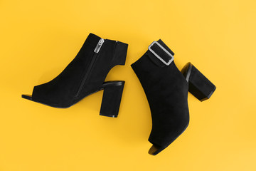 Female stylish shoes on color background