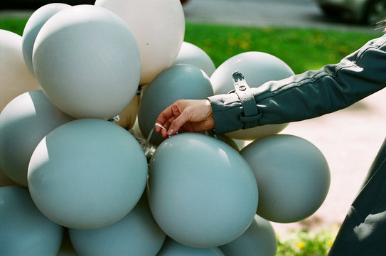 Woman holding grey and blue balloons