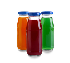 Different juices in bottles on white background