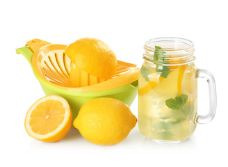 Fresh lemons, juicer and jar with lemonade on white background