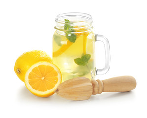 Fresh lemons, wooden juicer and jar with lemonade on white background