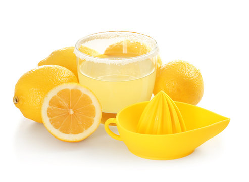 Fresh lemons, squeezer and glass of juice on white background