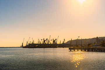Fototapeta na wymiar Transportation and logistic. Freight cargo cranes in seaport on sunset