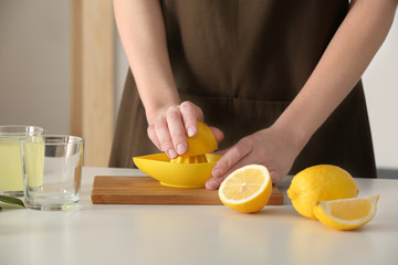 Obraz na płótnie Canvas Woman preparing lemonade in kitchen, closeup
