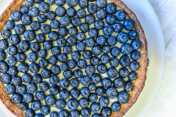 Blackberry pie and on rustic wooden table with yellow flower. Restaurant or home cooking concept