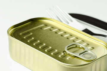 Close-up view of a can of food with a fork and a knife on a white background