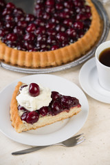 Kirschtorte mit Sahne und Tasse Kaffee