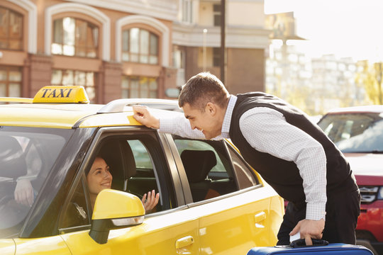 Handsome Man Talking To Female Taxi Driver Through Opened Window