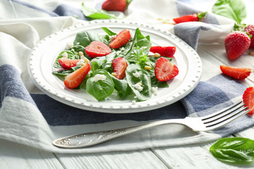 Tasty salad with spinach and strawberry on plate