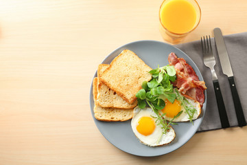 Tasty breakfast with fried eggs on table