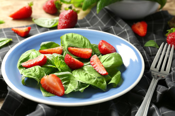 Tasty salad with spinach and strawberry on plate