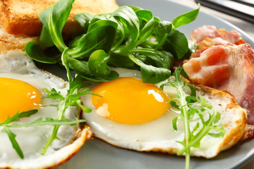 Tasty breakfast with fried eggs on plate, closeup