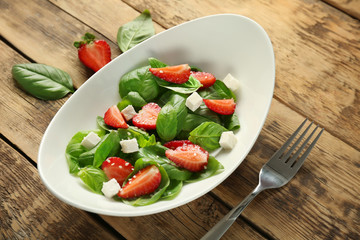 Tasty salad with spinach and strawberry on plate