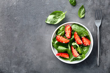 Tasty salad with spinach and strawberry on plate