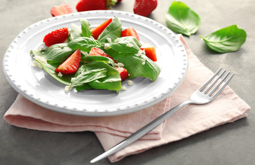 Tasty salad with spinach and strawberry on plate