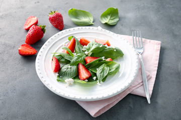 Tasty salad with spinach and strawberry on plate