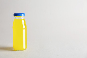 Delicious juice in bottle on light background