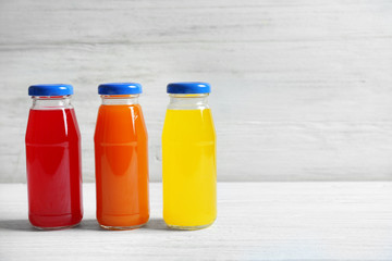 Delicious juices in bottles on wooden table