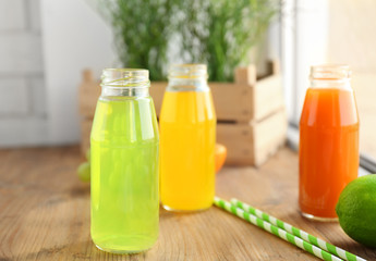 Delicious juices in bottles on window sill