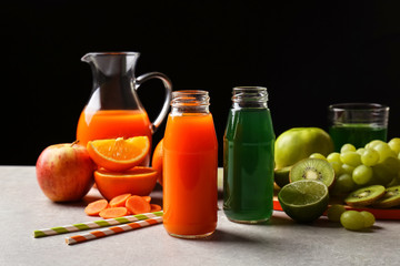 Delicious juices in bottles and fruits on table