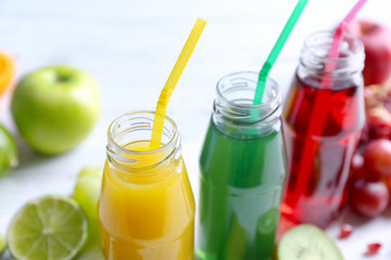 Delicious juices in bottles and fruits, closeup