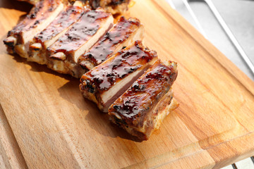 Delicious pork ribs on wooden board, closeup