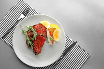 Plate with delicious pork ribs on table