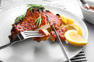 Eating delicious pork ribs in kitchen, closeup